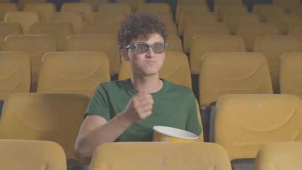 Portrait of Cheerful Young Man in 3d Glasses Catching Popcorn with Mouth in Cinema. Relaxed Handsome