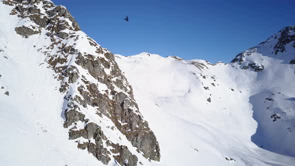 Flying in High Alpine Terrain on Sunny Winter Day