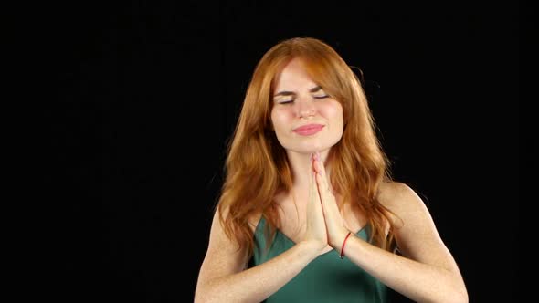 Girl Crosses Her Fingers and Hopes To Win. Black Background