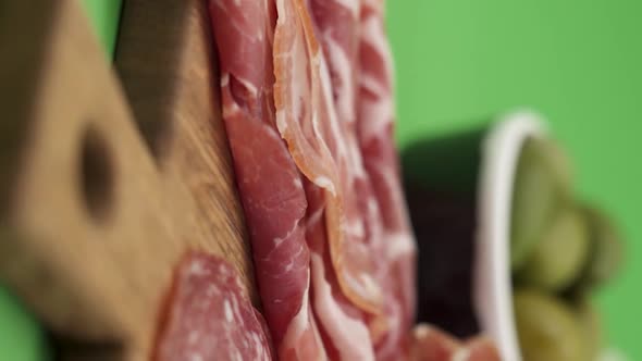 Vertical video, Close-up: cold cuts, salami, prosciutto, jamon, cherry tomatoes, sliced ​​sausage