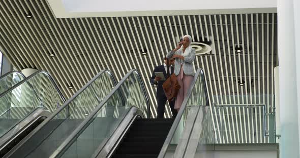 Young business people on an escalator in a modern building