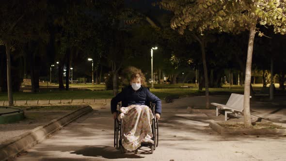 Handicapped boy in wheelchair in the park in late evening
