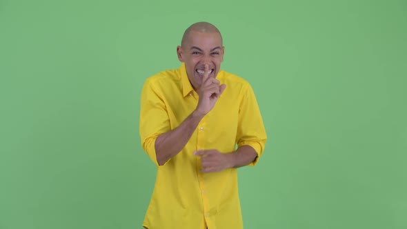 Happy Handsome Bald Businessman with Finger on Lips