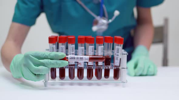 Doctor Nurse Woman Wearing Protective Mask and Latex Gloves - Working with Blood Test Tube Rack