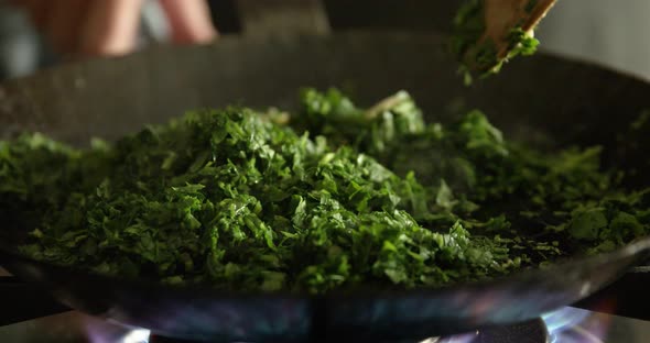 Woman steaming parsley for Maultaschen filling