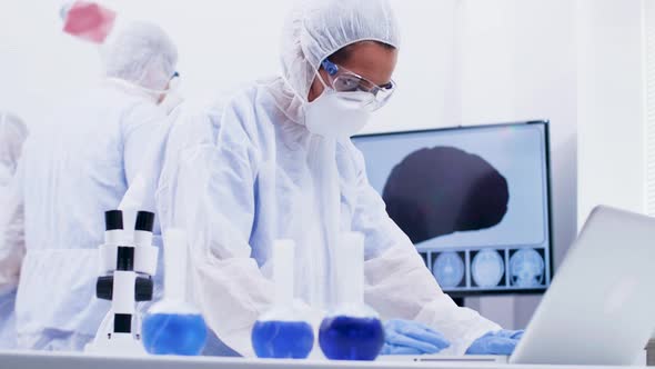 Female Scientist in Coverall Equipment Working on Computer in a Modern Science Laboratory alt