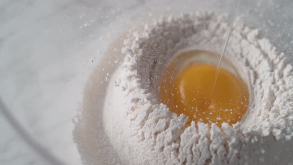 Egg falls on a pile of flour. Slow Motion.