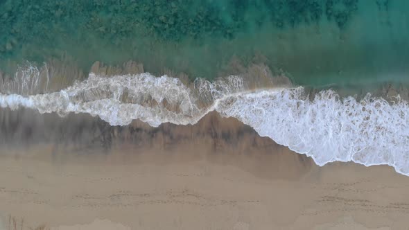 Waves crashing on Matadouro beach, Portugal. Aerial top-down static shot