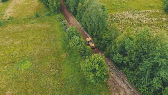 Aerial View A Bulldozer Leveling a Road Destroyed By Floods in a Mountainous Area. Heavy Machinery