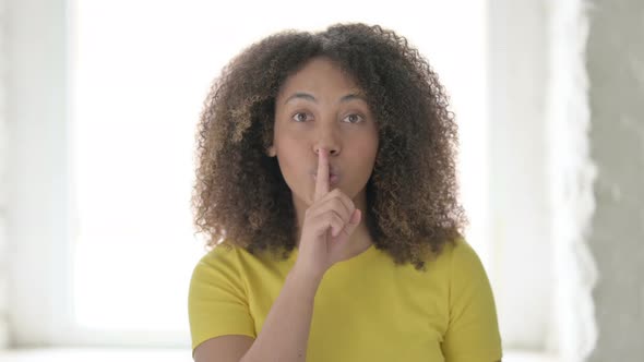 African Woman Showing Quiet Sign by Finger on Lips