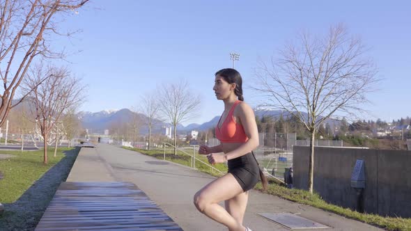 Young fit girl exercising step-up knee lift outdoors