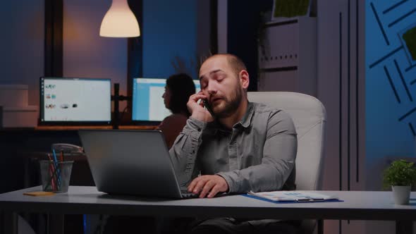 Exhausted Businessman Sitting at Desk Table Discussing Management Ideas