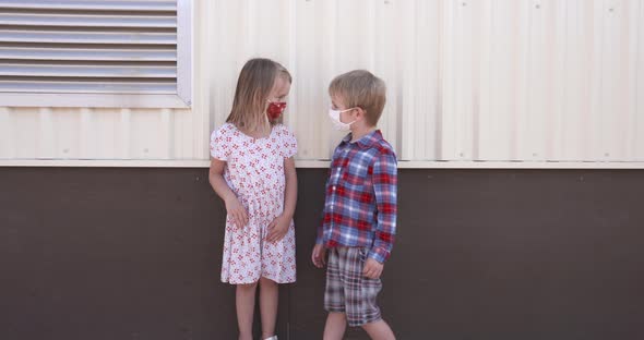 School children in masks demonstrating physical distancing.