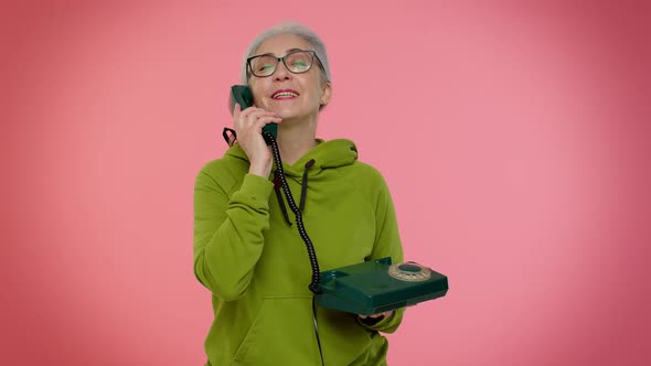 Senior Granny Grayhaired Woman Talking on Wired Vintage Telephone of 80s Says Hey you Call Me Back