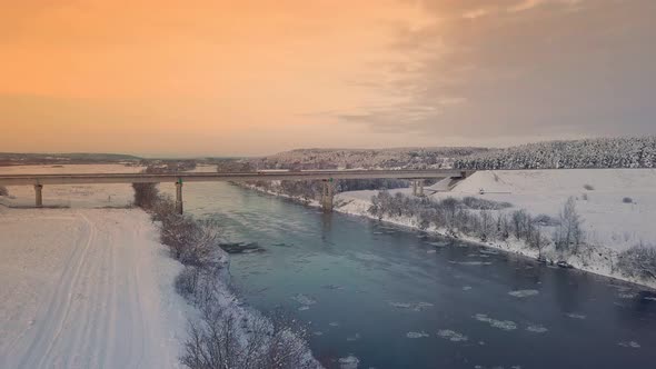 Drone shooting of a river against the background of a forest and a bridge