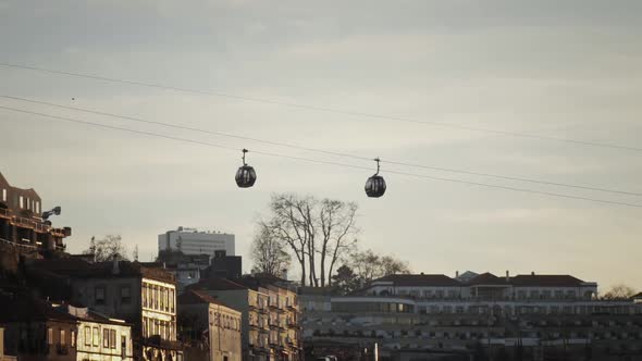 Two cable cars moving away from each other in slow motion in Porto