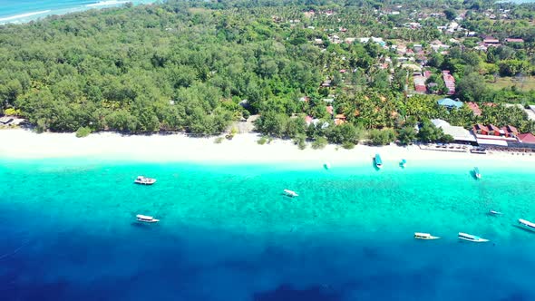 Boats floating over blue azure sea, washing white sandy beach of tropical island with lush vegetatio