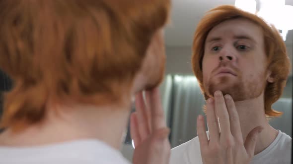 Redhead Beard Man Checking at His Teeth in Mirror