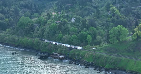 Aerial view of Georgian railway high speed train moving near the sea in Tsikhisdziri. Georgia 2022