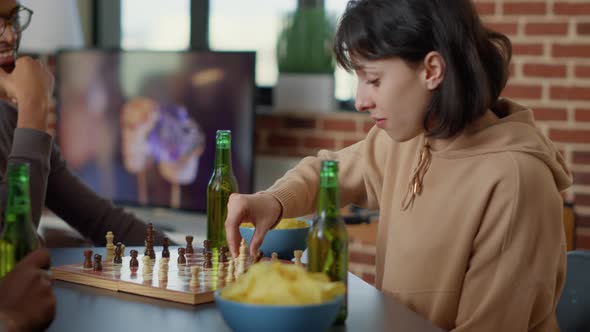 Focused Woman Playing Strategic Board Games with Friends