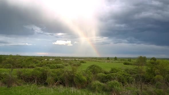 Picturesque Rainbow Over Green Meadow with Lakes Upper View