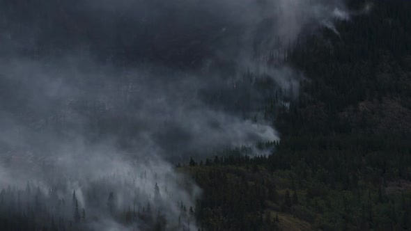 Wildfire Smoking on Side of Mountain Next To Lake  Time Lapse