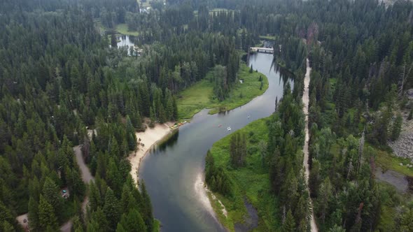 Overhead drone shot of paddleboarders and kayakers on the winding Payette River in the Idaho wildern