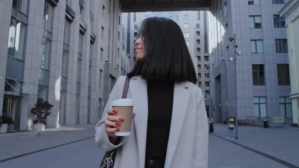 Young Adult Asian Businesswoman Walking From Office with a Coffee Cup in Slow Motion