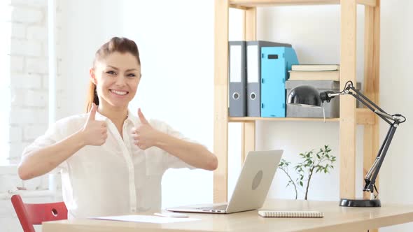 Thumbs Up by Woman Sitting in Office