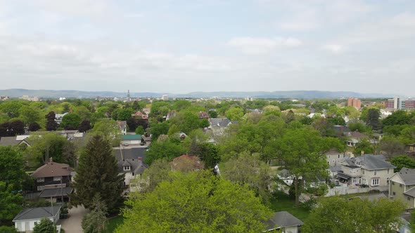 Aerial view over diverse residential neighborhood with church and tree lined streets.