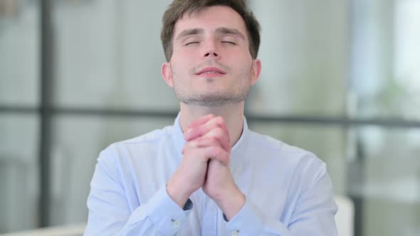 Young Man Praying with Eyes Closed