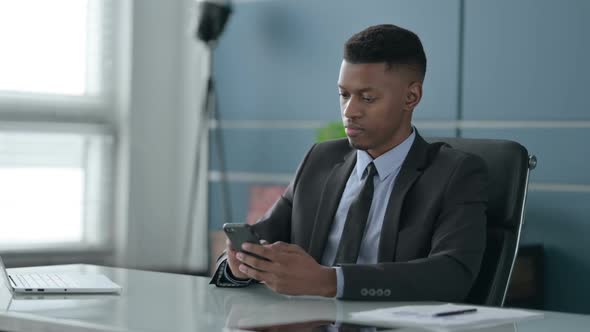 African Businessman using Smartphone in Office