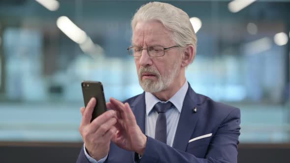 Portrait of Old Businessman Using Smartphone