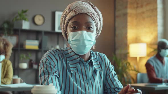 Portrait of African American Businesswoman in Mask in Office