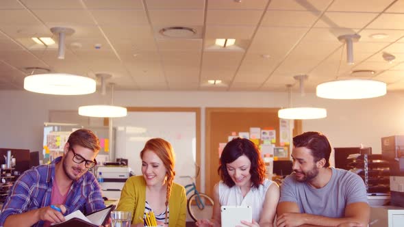 Business colleagues discussing over digital tablet