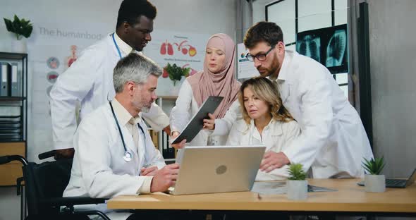 Muslim Female Medical Worker in Hijab Caming to Respected Bearded Doctor to Make Sign