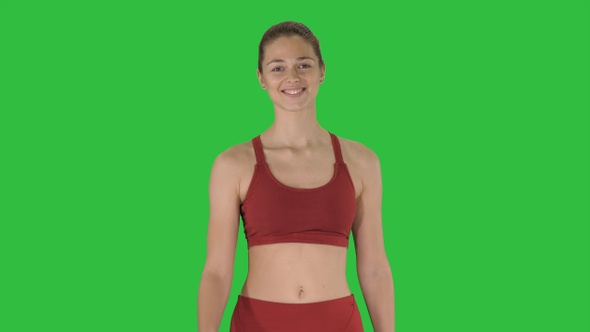 Smiling sports woman walking and smiling on a Green Screen