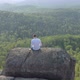 Top View of a Man with a Laptop on the Edge of a Cliff. - VideoHive Item for Sale
