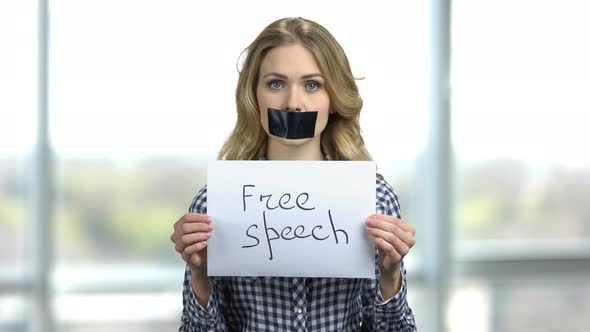 Portrait of Young Woman with Taped Mouth and Banner with Free Speech Text