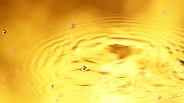 Super Slow Motion Detail Shot of Water Drop on Golden Luxury Background at 1000 Fps
