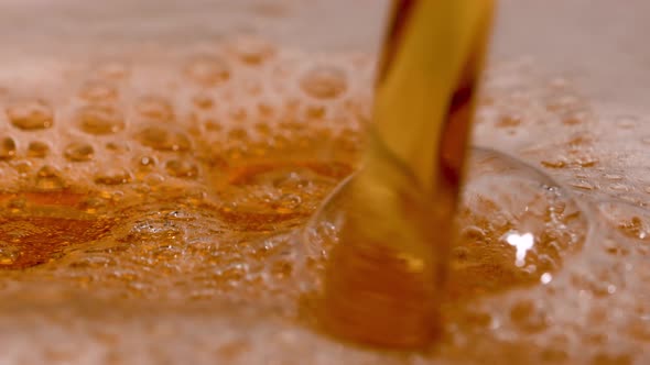 Detailed Macro Shot of Light Beer Being Poured Into a Glass