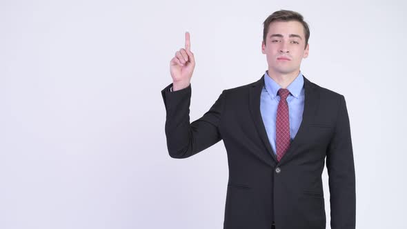 Young Happy Handsome Businessman Thinking While Pointing Up