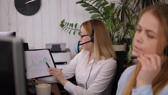 Two Business Women with Headset are Working in a Call Center and Drinking Coffee