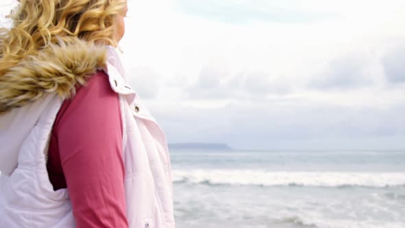 Woman standing with her bicycle on beach