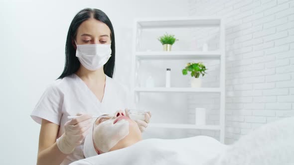 Beautician Applies Mask on Woman's Face in Salon