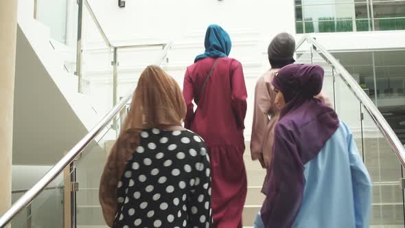 Group of Four Muslim Girls Walking at Stairs of Shopping Mall