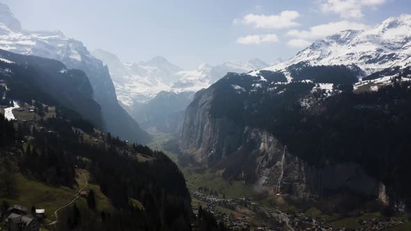 Aerial is flying high up from Wengen and shows Lauterbrunnen Town from a distance, Switzerland