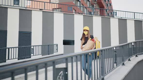 Caucasian Girl Delivery Worker in Gloves Cap and Medical Mask Walking the Street