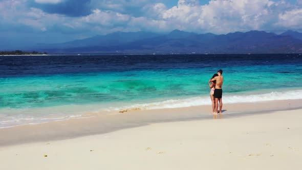 Teenage lovers in love on beautiful sea view beach holiday by blue sea and bright sand background of