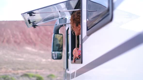 Happy tourist woman admire destination from camper window. Cheerful excited female people
